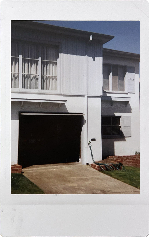 A white house with an open garage door.