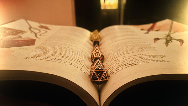 An opened book with multi-sided dice resting in the gutter of the pages.